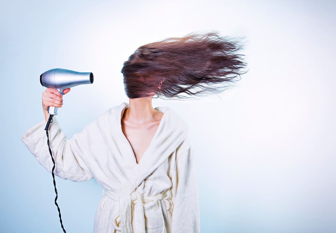 אישה עושה פן עם מייבש שיער