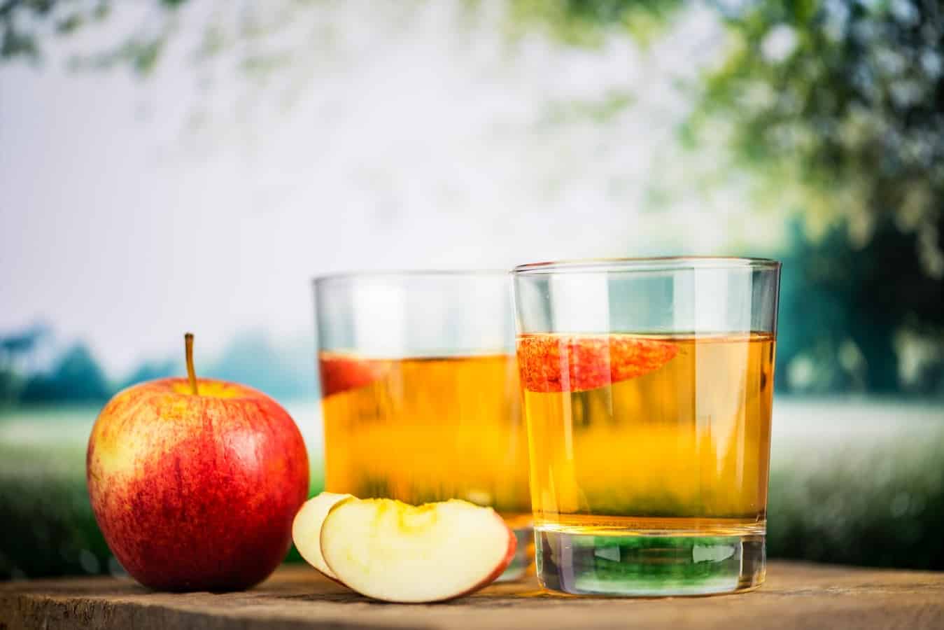 כוסות עם סיידר תפוחים על שולחן בטבע