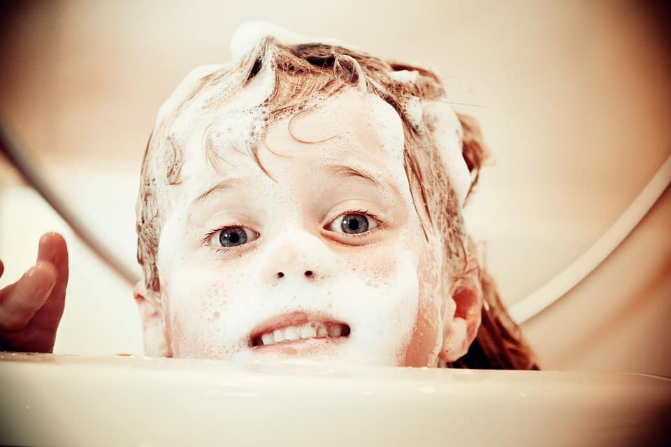אילוסטרציה של ילד שעושה טיפול עם שמפו ניזורל