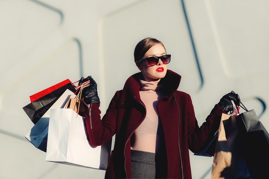 אישה מחזיקה תיקים מלאים במוצרים אחרי מסע קניות