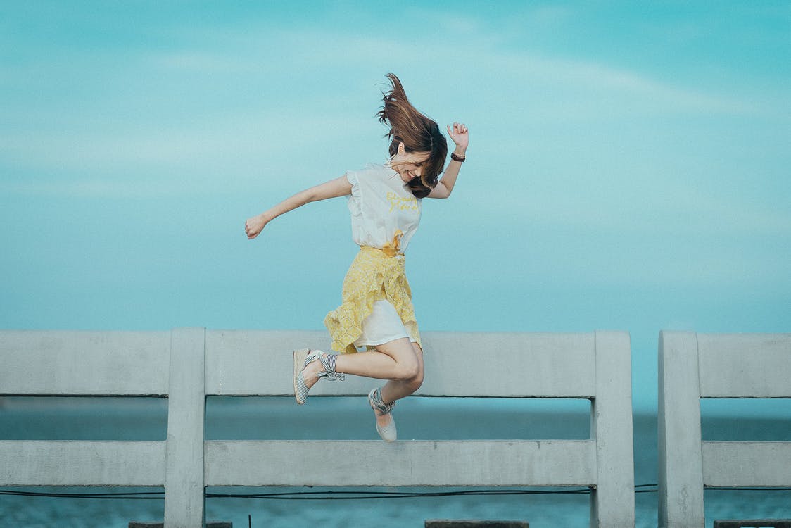 בחורה צעירה קופצת באוויר ומחייכת